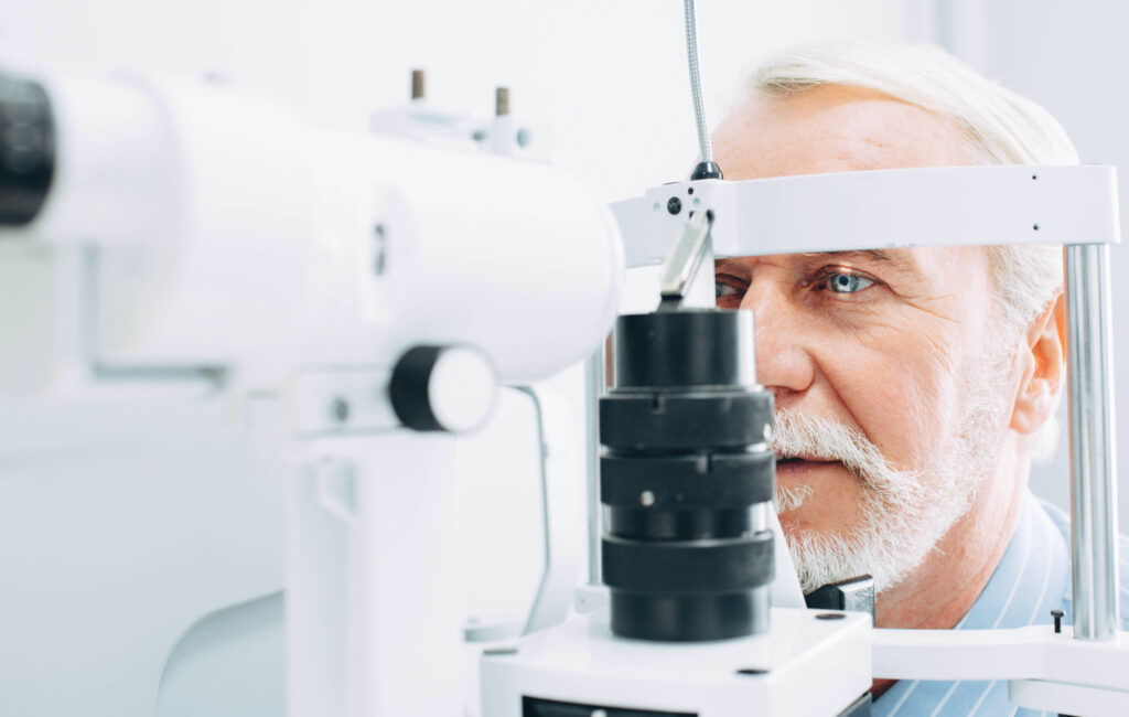 Senior patient checking vision with special eye equipment